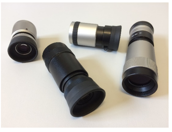 Fotografie von vier zylinderförmigen Hand-Fernrohren. Sie sind unterschiedlich lang und schwarz- oder silberfarben. 
