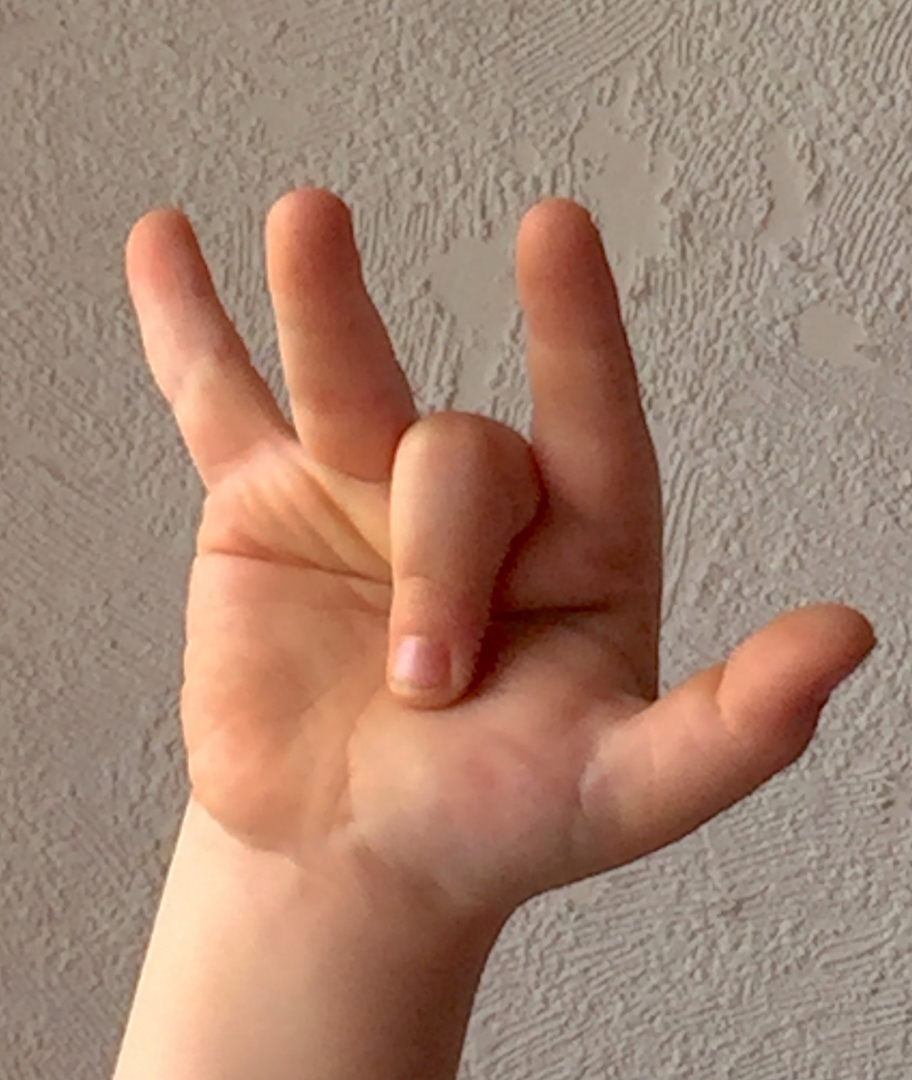 Foto einer Kinderhand. Der Mittelfinger zeigt in die Handinnenfläche. Alle anderen Finger sind ausgestreckt.