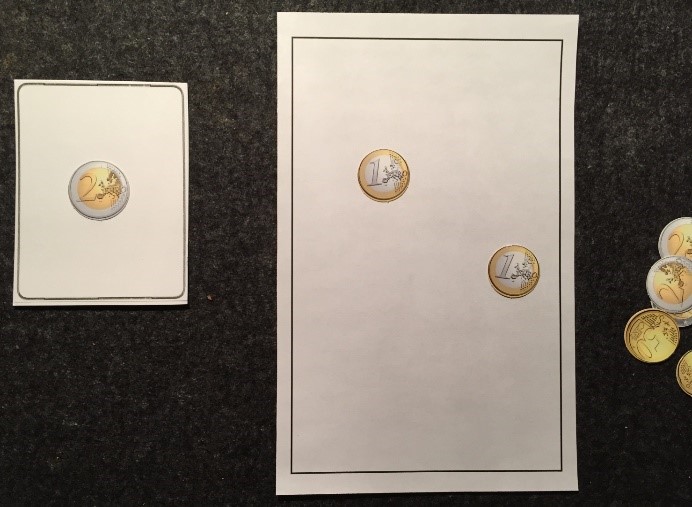 Links: Karte mit einer Zweieuromünze. Rechts: Sortiertafel mit zwei Eineuromünzen. Rechts daneben weitere Geldmünzen.